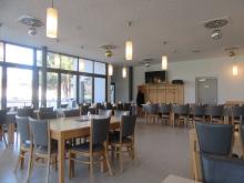Speisesaal mit mehreren Tischen und Sesseln